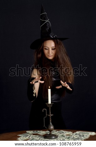 Lovely girl as a witch on a dark background