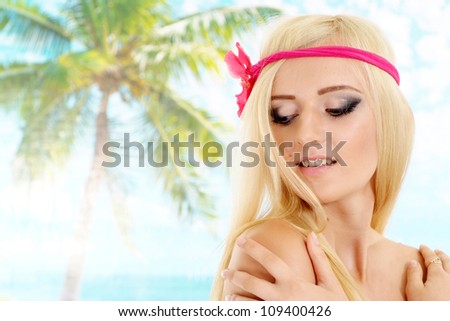 Beautiful blonde with a bright appearance is resting at a resort