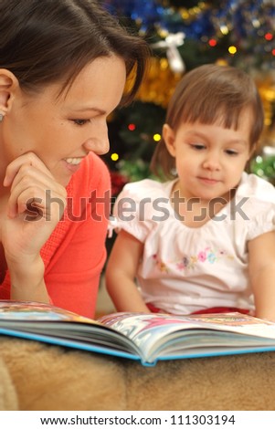 pretty mom reading with her little daughter