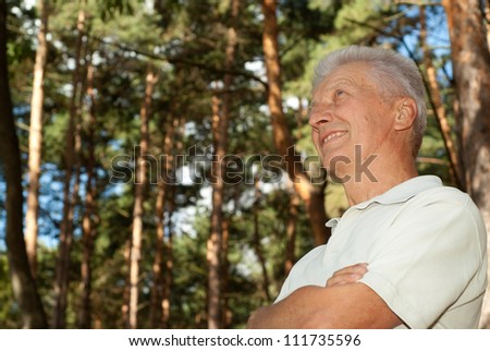 Beautiful elderly man went for a walk in the forest