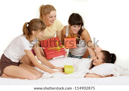 Four nice young girl with gifts on bed