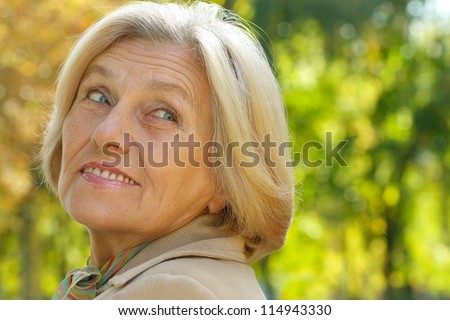 Portrait of an old beautiful woman in autumn outdoors