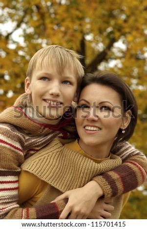 happy mom and son on autumn background