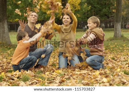 portrait of a happy family throw autumn leaves
