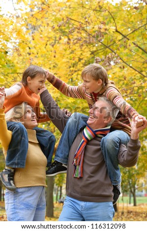 portrait of happy elderly couple and children rest fall