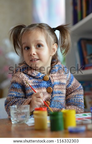 beautiful cute baby girl draws paint in the room