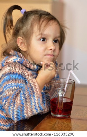 Portrait of a cute child drinking tea in the room