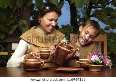Happy mother and son sitting at the table