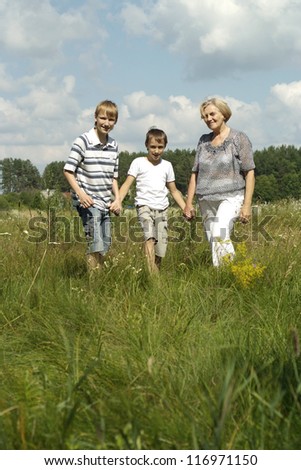 nice grandmother and her grandsons in a summer park