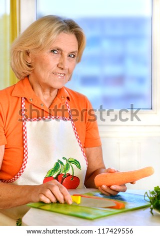 beautiful elderly woman preparing food in the kitchen