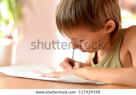 nice little boy at a desk writing