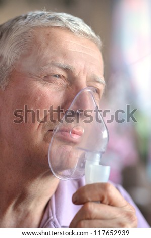 close-up of an old man doing inhalation