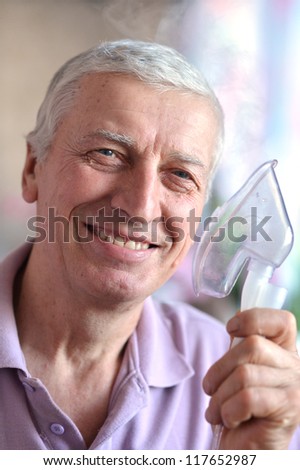 close-up of an old man with an inhaler in hand