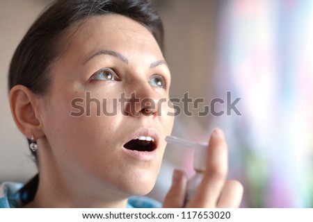 young woman with spray inhaler in hand