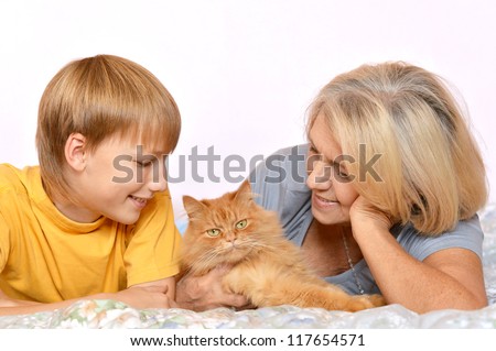 Pretty happy grandmother and grandson looking at pet cat