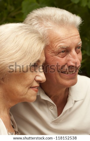 Amusing older couple sitting at a table at home on the veranda