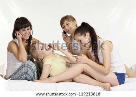 nice girls with phones on the bed
