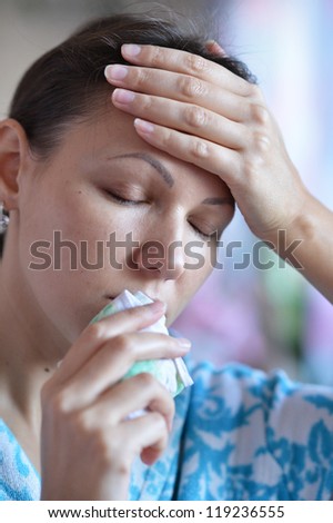 Young woman with handkerchief having cold with fever