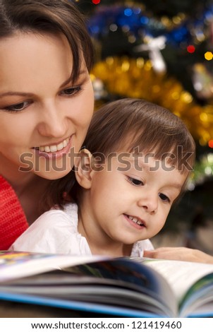 Little girl and mom sitting at a table with a book