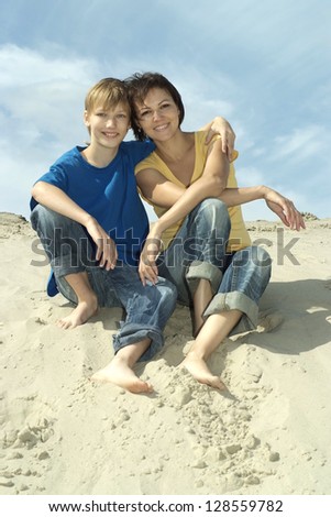 beautiful mom with child in the sand