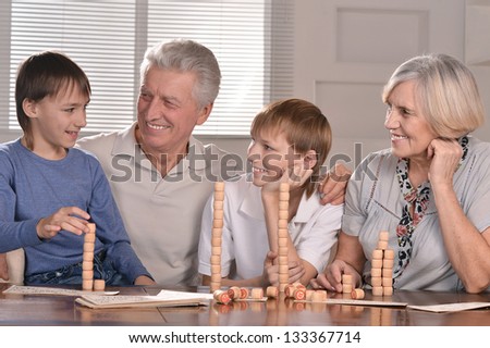 Portrait of two boys and grandparents playing lotto at home