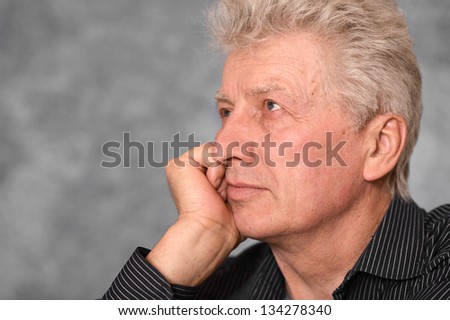 portrait of older man in a shirt over  gray background