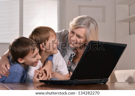 Portrait of two boys and grandmother with a laptop at home