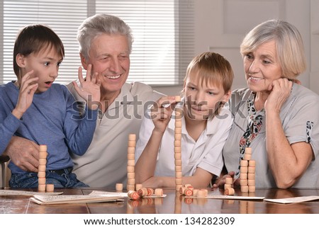 Portrait of two boys and grandparents playing lotto at home