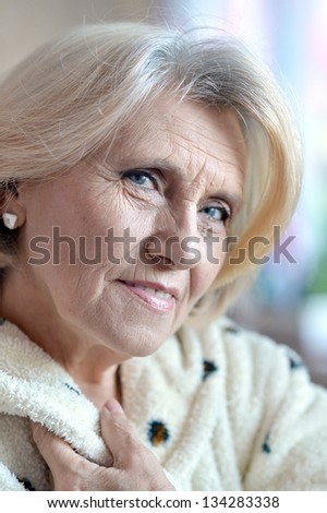 close-up portrait of an elderly woman in a bathrobe at home