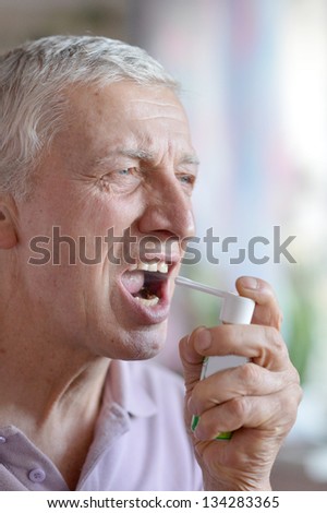 close-up portrait of an older man taking a  medicine