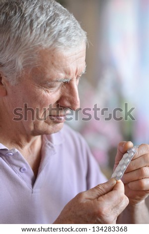 close-up portrait of an older man taking a  medicine