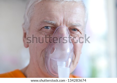 close-up portrait of an elderly man making inhalation