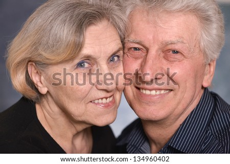 portrait of a happy senior couple over a gray background