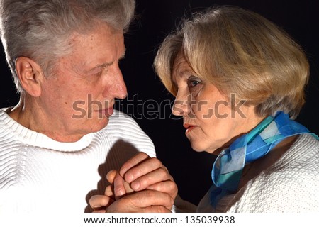 close-up portrait of an elderly couple on a black background