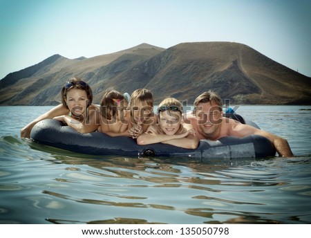 portrait of a happy family swimming on an air mattress