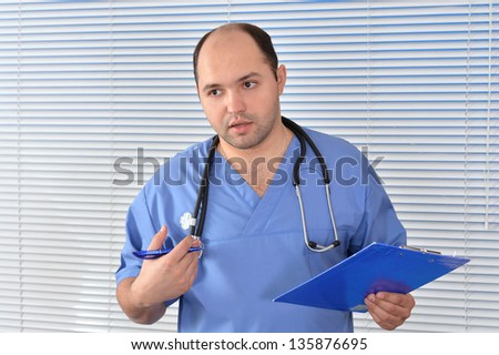 Studio portrait of a doctor in blue uniform  over texture background