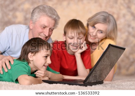 elderly couple and their grandchildren resting at a laptop
