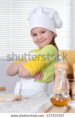 nice girl in a hat chef knead the dough for the cake