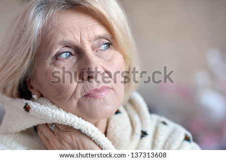 close-up portrait of an elderly woman in a bathrobe at home