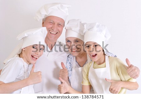 older couple and their grandchildren knead the dough for biscuits together