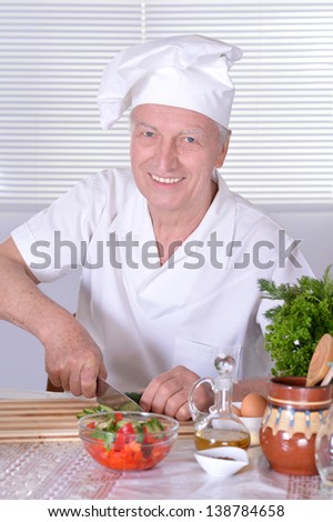 elderly man chef cooking tasty vegetable salad