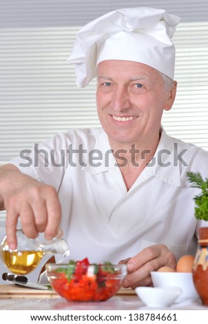 elderly man chef cooking tasty vegetable salad