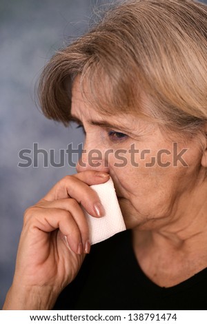 depressed old woman  on a gray background