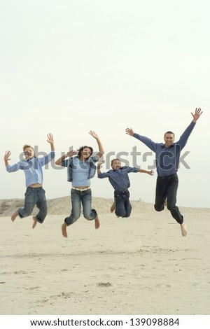 happy family of four people jumping outdoors