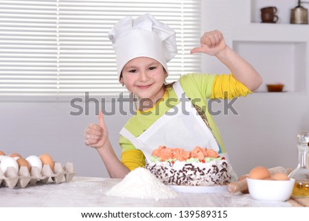 little girl in chef hat with a sweet cake