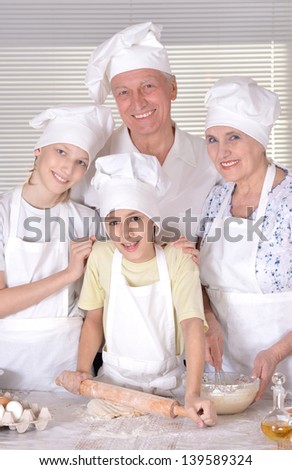an elderly couple and their grandson knead the dough for the pie together