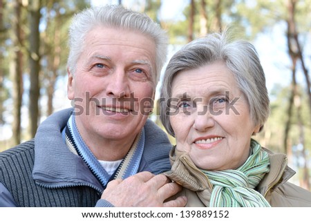happy elder couple on a walk in the forest in the spring