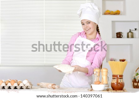 Cute girl baking cake in the kitchen at home