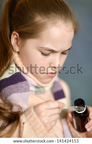 portrait of a lovely little girl takes medicine
