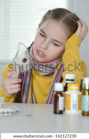 Portrait of a young girl in a yellow sweater takes medicine
